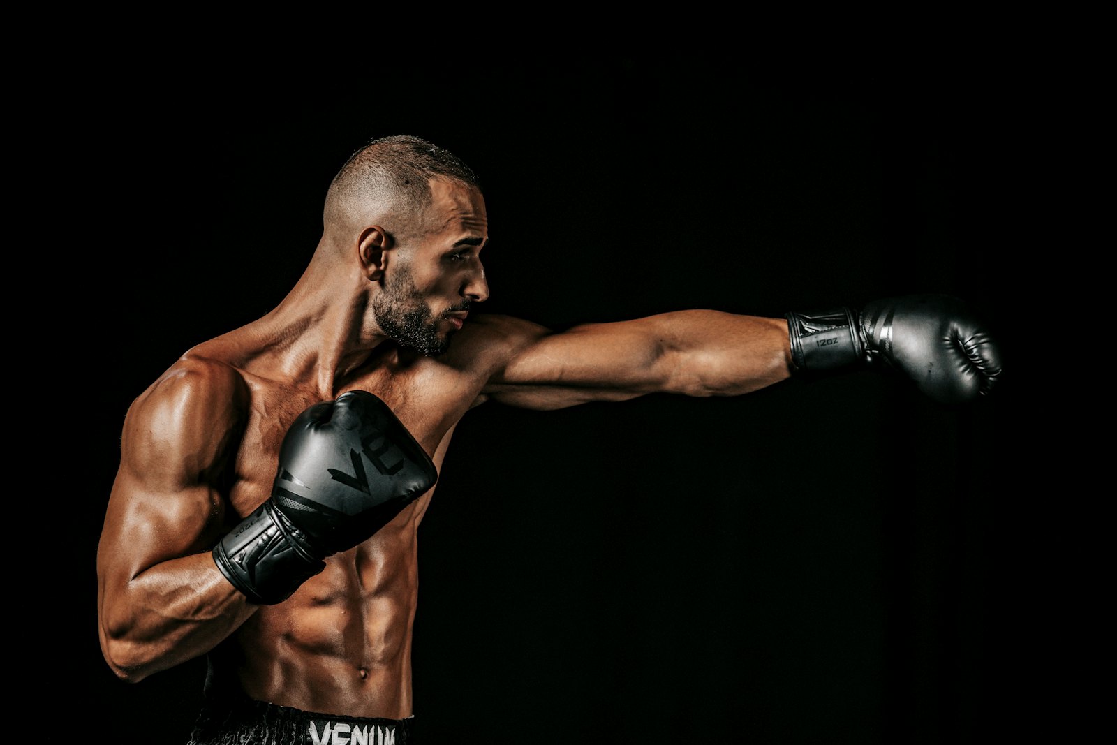 Boxer throwing a punch in a dark gym