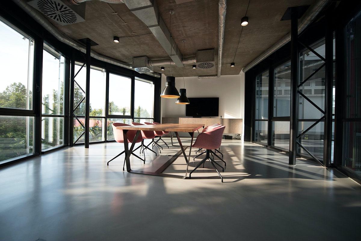 Bright industrial studio with a long table and tall steel windows