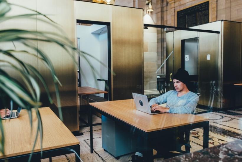 Workspace with a timber desk and a person working on a laptop